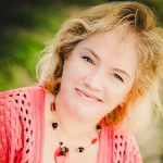 Smiling woman in pink outdoor setting.